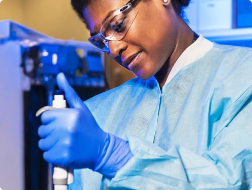 a woman wearing protective gear and gloves holding a tube
